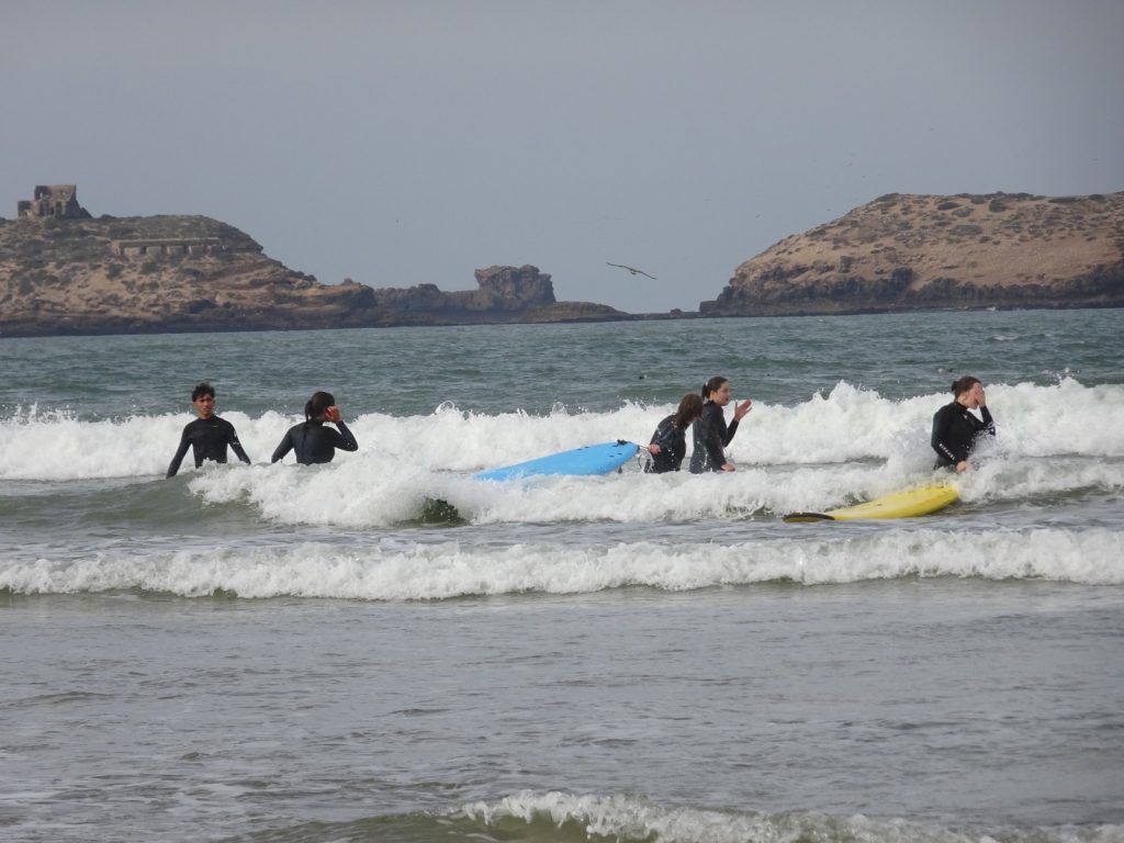 Students Surfing in front of the cliffs