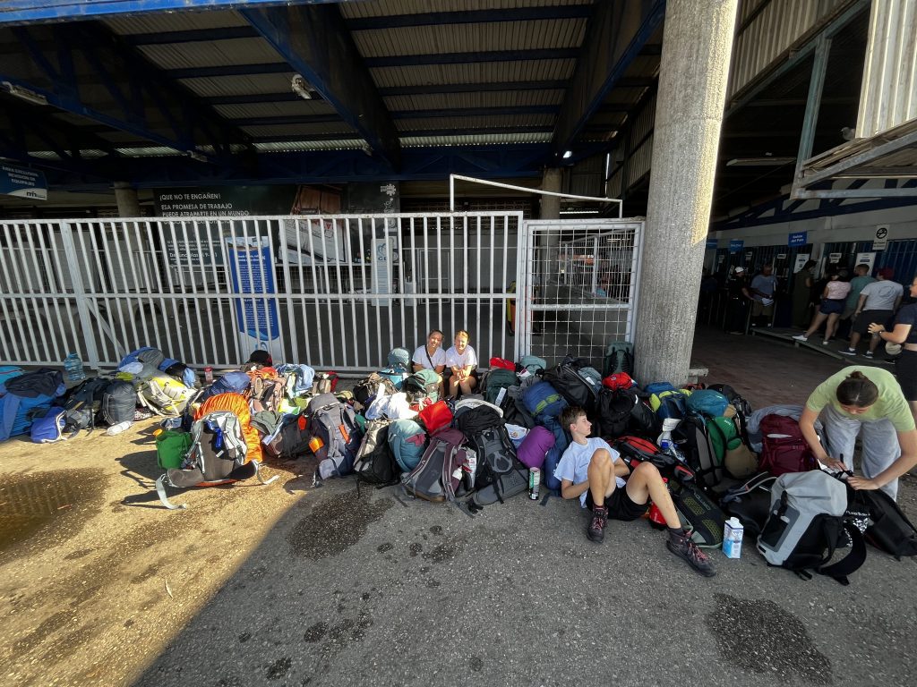 Schüler*innen mit Gepäck warten an der Grenze von Panama und Costa Rica