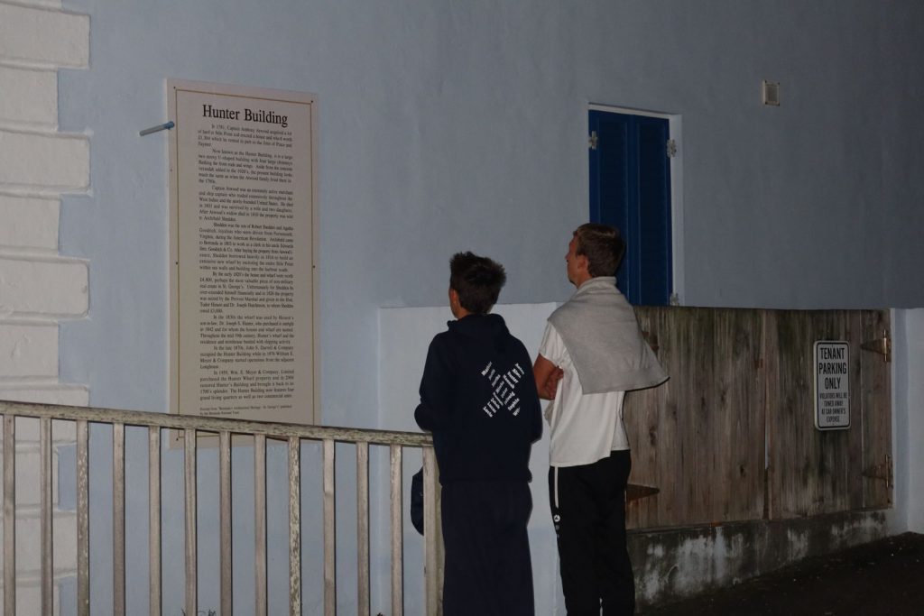 Students reading a historic text on a building.