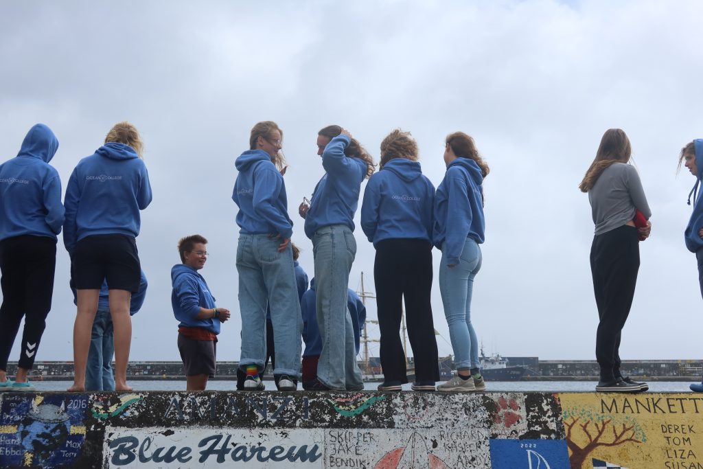 Schüler*innen stehen auf der Hafenmauer der Azoren.
