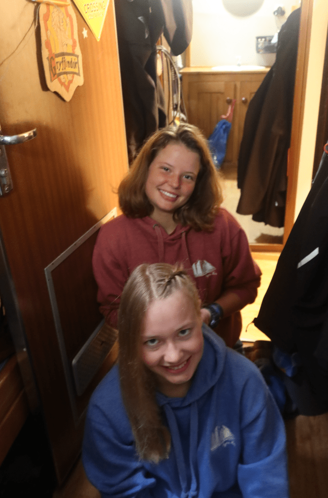 Schüler*innen flechten sich in den Cabins die Haare.